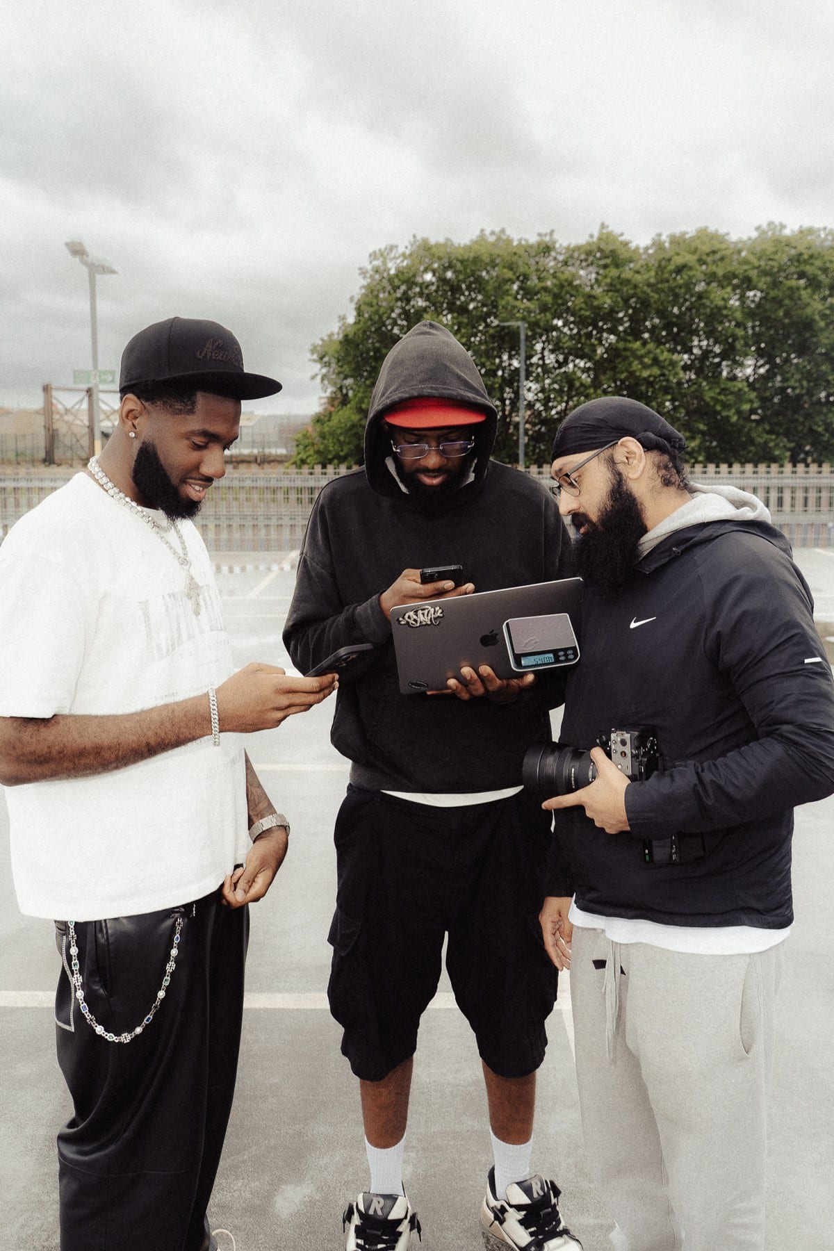 Julio Ade and the production crew reviewing a device during an outdoor shoot